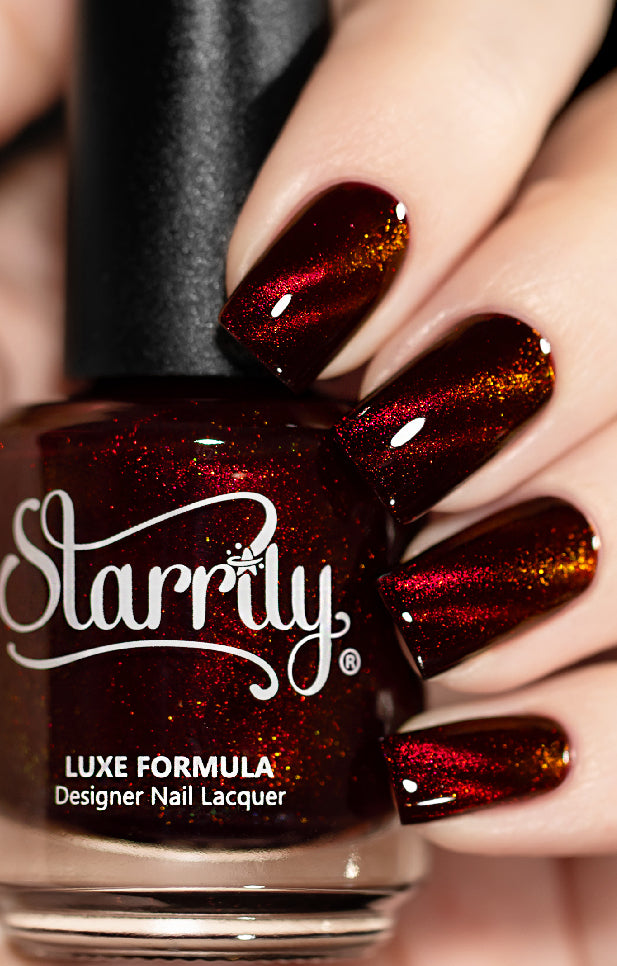 A close-up image of a hand with nails painted in a red magnetic color, holding a nail polish bottle with the brand name 'Starrily' on it.